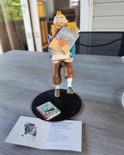Tintin tenant les albums 