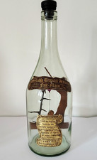 Bouteille de vin en verre vide avec personnage en bois artisanal pêcheur