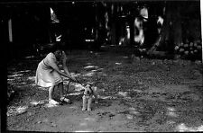 Woman pulling on dog leash - old photo negative year. 1950