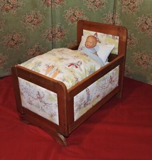 Lit de poupée en bois capitonné ancien tissu Cadet Roussel
