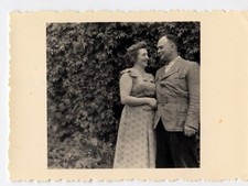 Family portrait couple in front of hedge garden - old photo year. 1950