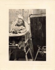 OLD PHOTOGRAPH YOUNG CHILD IN HIGH CHAIR AT MEALTIME