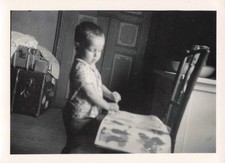 OLD PHOTOGRAPH CIRCA 1950 CHILD READING AND LARGE SUITCASES