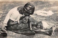 Old postcard NIGER BABY RECEIVING A CHILI ENEMA 