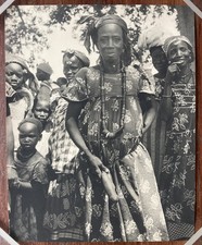 Femme africaine enceinte portant à la taille un phallus en bois. Fétiche.