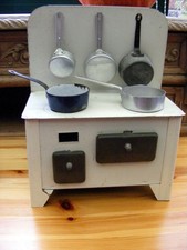 Jouets cuisinière en tôle ancien avec 5 petites casseroles en bon état.