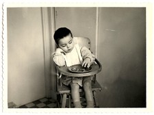 Child in high chair eating - 2 old photos year. 1960