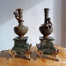 Paire de vases en régule sur socle en marbre à décor de Putti