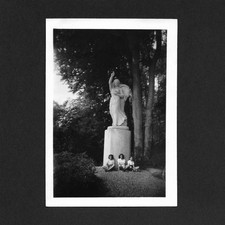 3 filles au pied d'une statue