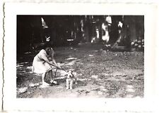 Young woman with chien on leash - old year photo. 1950