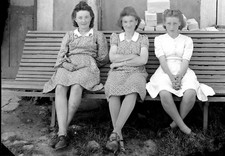Portrait of young women sitting in front of house - old negative photo year. 1940
