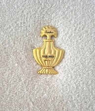 Pin's en métal doré GUERLAIN