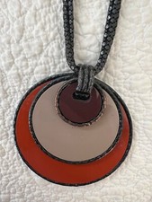 La Tribu Rigaux necklace. Black chain, orange medallion.  Very good condition.