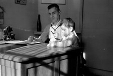 Man at his desk with child - Old photo negative year. 1950