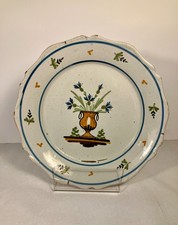 Nevers, fin XVIIIème siècle. Assiette galbée en faïence à décor de pot fleuri.