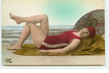 Young woman in bathing suit lying on a towel and protected by - 21702
