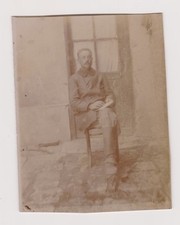 old photo ?️ soldier prisoner sitting holding notebook in front of glass door