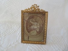 old bronze photo frame topped with flower basket and arrow