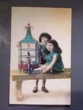 Old postcard two children with a bird cage