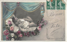 CP BON FETE BABY ON CUSHION WITH ROSES UNDER CURTAINS