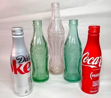 COCA-COLA: THREE VINTAGE GLASS COCA COLA BOTTLES – 2 ALUMINUM BOTTLES