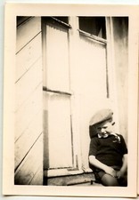 Child cap sitting window edge - old photo year. 1940