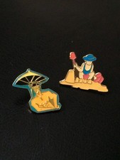 2 pin's thème Plage - fillette château de sable / homme parasol