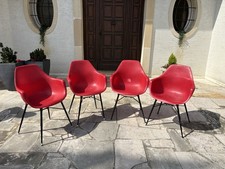 Modernist chairs with red plastic seat and tubular bases black