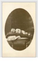 CHILD.BEBE LYING ON A TABLE