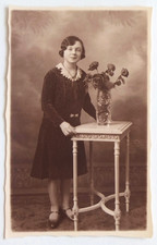 Elegant bourgeois girl leans pedestal - old photo postcard studio