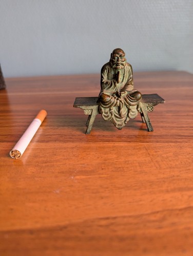 Bronze sage assis sur banc