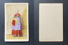 Girl in regional suit posing in front of a haystack, straw and sawn