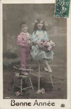 CP GOOD YEAR LITTLE GIRL ON SADDLE BASKET PINK BOY ON CHAIR FLOWERS