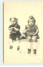 Two girls sitting on a bench, with their cuddly toys - 22745