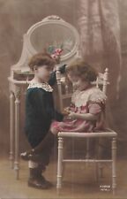 CP BOY HOLDING HANDS LITTLE GIRL ON DRESSING CHAIR