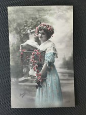 Old postcard a young woman in blue dress with a bird cage 
