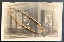 Photo card to identify. Store front, people in front of the shop.