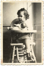 Child in high chair with doll baby - old year photo. 1940
