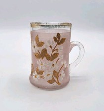 Tasse en verre soufflé teinté rose émaillé à décor floral et doré début XXème 