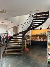 escalier ancien en métal finition rouillé. Forme colimaçon. Marches en bois.