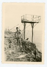 PHOTO snapshot, a man in a jersey topless fisherman rock coast ocean
