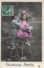 CP HEUREUSE ANNEE GARCON DEBOUT SUR CHAISE COIFFANT PETITE FILLE DE FLEURS